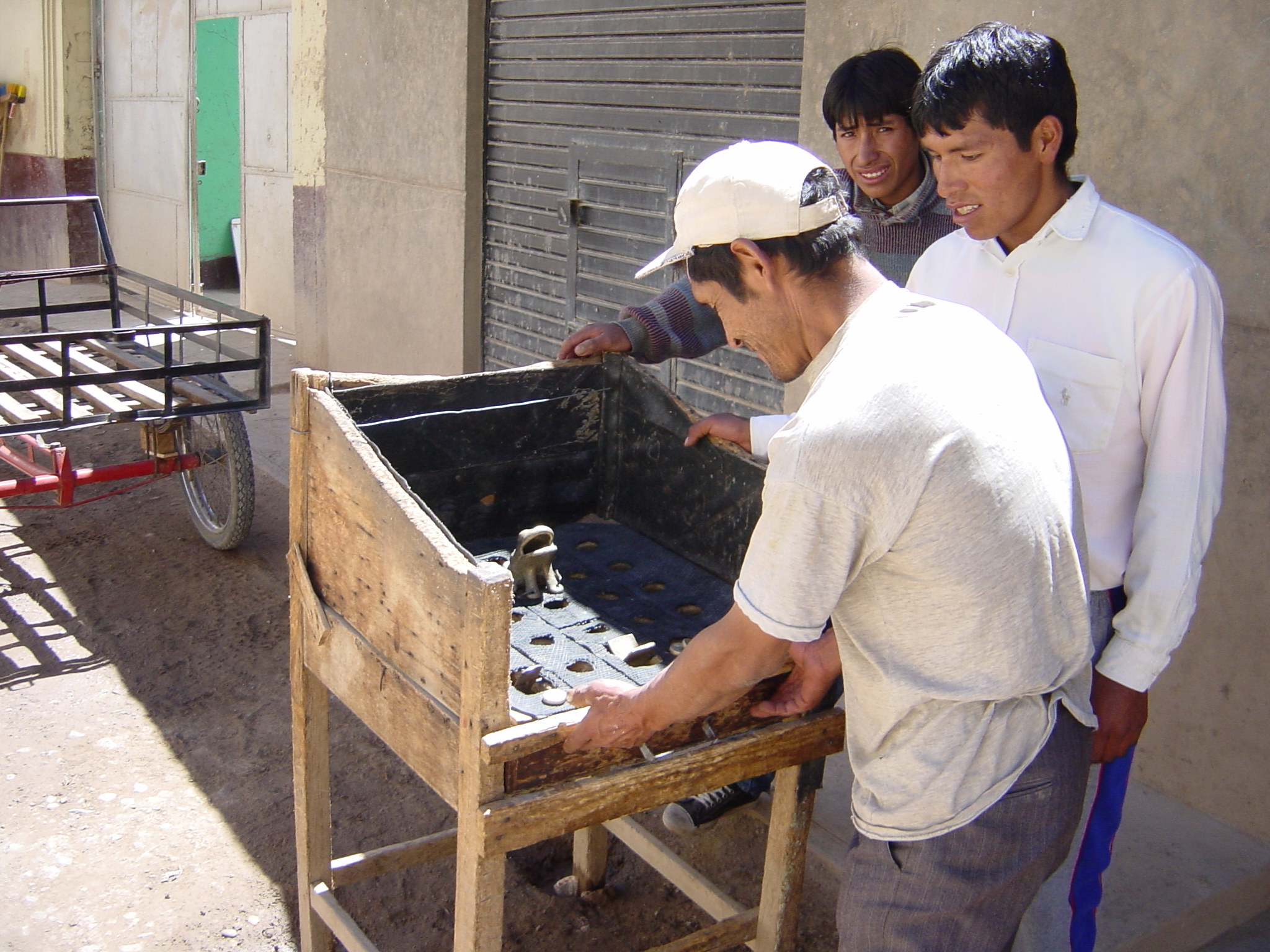Locals playing a game which we call 'Toss the coin into the frog's mouth and get the most points to win'.