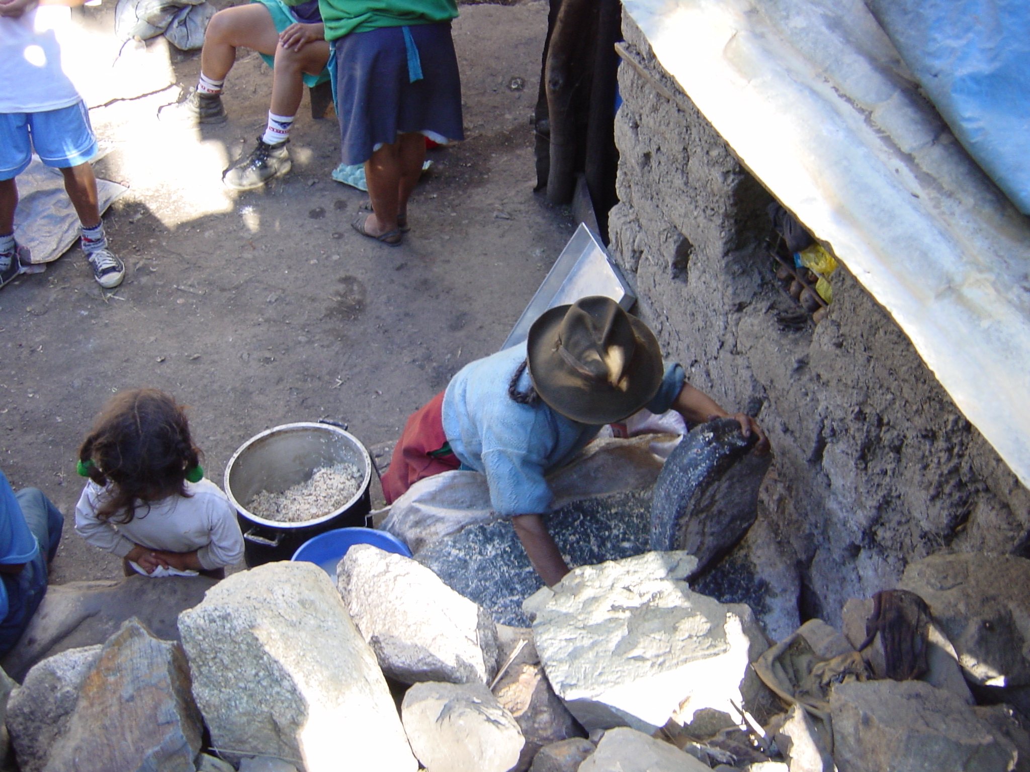 Old lady using a stone to crush corn to make an alcoholic drink called... well, none of the locals seemed to know after a couple.